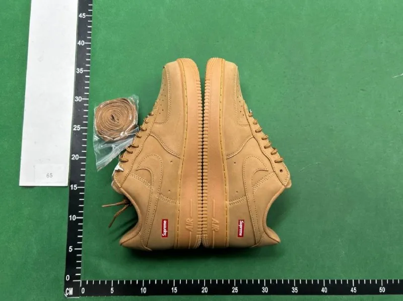 Two tan low-top shoes with side panels visible on a green ruler-marked surface